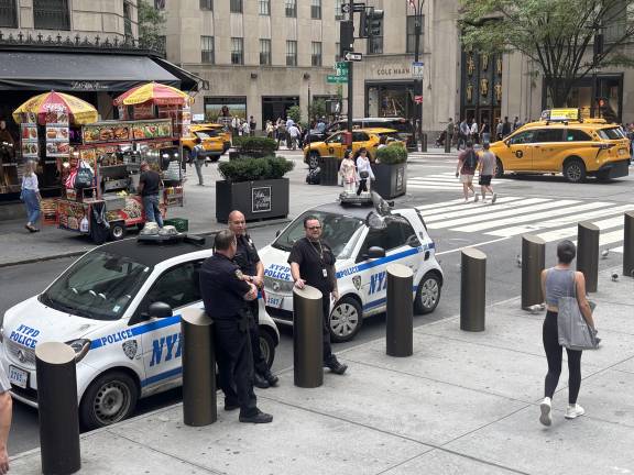 Police stand guard outside St. Patrick’s Cathedral, a day after a shooting at a Catholic church in Minneapolis killed two children and wounded 17 people. The NYPD said they were stepping up police presence at houses of worship across the city, but added they had not received any credible threats.