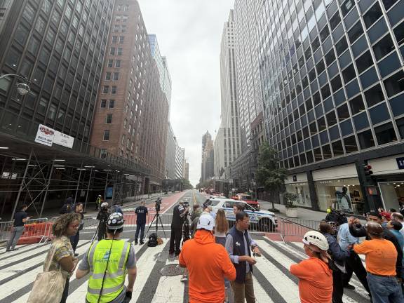 Press gathers on Third Avenue while building workers take questions.