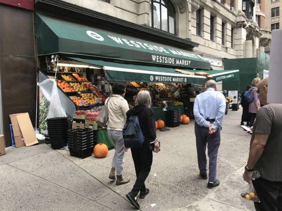 A weekend street scene outside the Westside Market on Broadway just south of 77th Street, which has been its home since 1979. The supermarket's lease with the parent company of the Hotel Belleclaire, its landlord, expires on November 30. Photo: Douglas Feiden