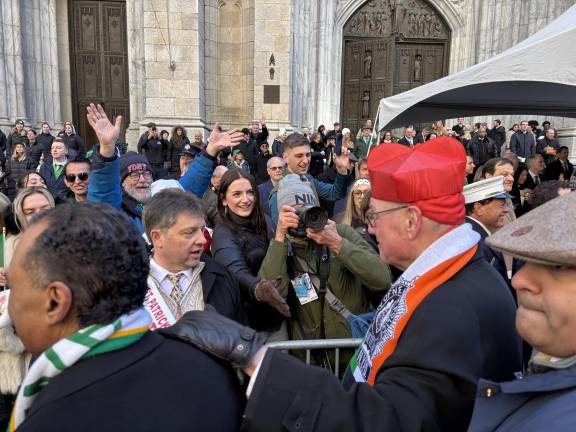 Cardinal Timothy Dolan gets an exuberant welcome from spectators at the foot of St. Patrick’s Cathedral. For the first time in 17 years, Dolan is a passing marcher, rather than the chief greeter.