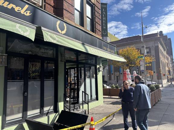 Kevin Mulligan, owner of The Laurels Cafe, huddles with building landlord Josef Yusuf Bildirici on Oct. 26 after a fire erupted in the basement of the restaurant,m at Second Avenue and East 14th Street.