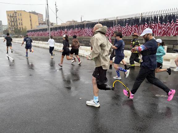Runners making their way past the flag festooned border of the Battery Tunnel.