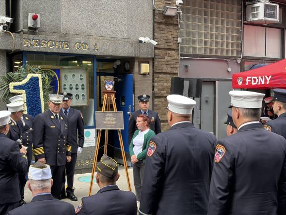 FDNY Firefighter Stay Clark (in white and green) next to Aaron’s plaque.