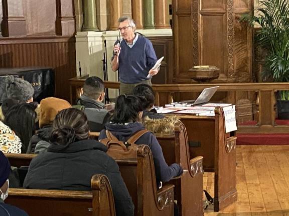 TJ Mills, managing attorney at New York Justice for Our Neighbors, addresses a roomful of recent immigrant arrivals on their legal rights. Photo: Stephan Russo