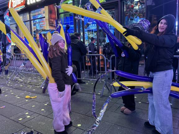 Despite the annoyance of stepped security and bone chilling temperatures, Times Square on New Year’s Eve still has allure. These spectators enjoyed themselves and snagged Planet Fitness balloons.