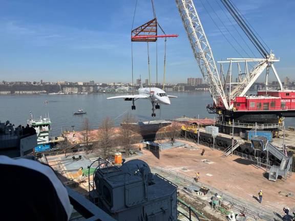 No easy job for the 80-ton jetliner to be lifted by crane onto Pier 86 following its return from a seven month rehab at the Brooklyn Navy Yard.