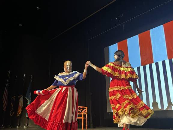 The models dance together in cultural outfits.