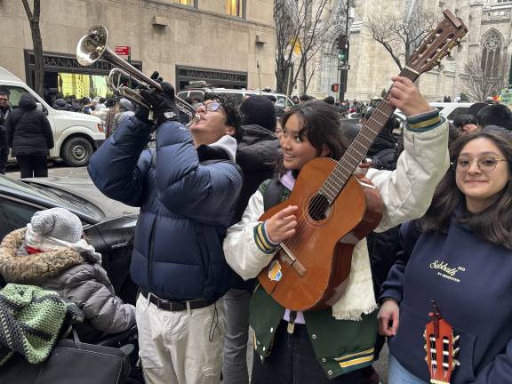 A trio of performers, (from left) Chris Calle (on trumpet), Amelia Meade an Julieana Alguera (on guitars) celebrated the new archbishop with music and song in the streets around St. Patrick’s Cathedral of Feb. 6.