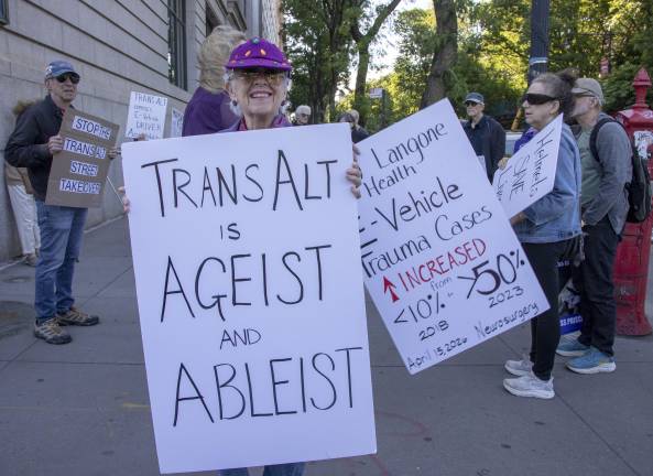 Sandy Rayburn attends a protest outside the New-York Historical Society, where opponents of current e-bike policies gathered during a Transportation Alternatives fundraiser.