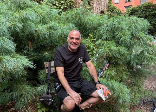 Local artist John Just, who said he lived in Hawaii for years, enjoys the chance to read a book in a peaceful garden setting.