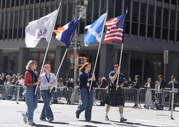 Tartan Day Parade marchers and spectators, everyone smiling in the sun.