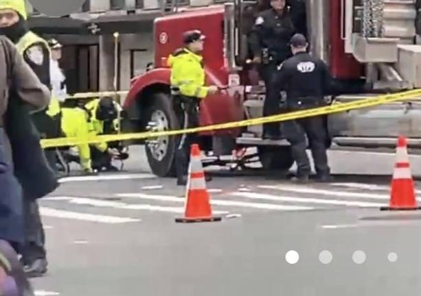 Police check out the tractor trailer than ran over a 46-year-old woman on Second Ave. as the truck was turning onto 57th St. heading west. The pedal bike the critically injured woman was driving can be seen under neath the truck near the front wheel.