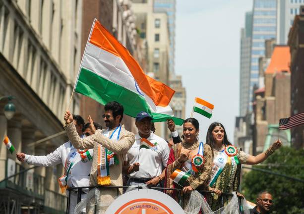 Grand Marshals Vijay Deverakonda (holding flag) and Rashmikka Mandanna flank Mayor Adams on the lead float at the India Day Parade, Aug. 17.