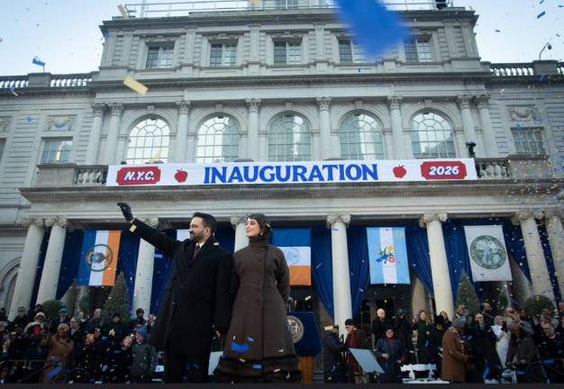 Mayor Zohran Mamdani waves to supporters at his swearing in ceremony at City Hall on Jan. 1. He was accompanied by his wife Rama Duwaji, who held the Quaran as he was sworn in as the first ever Muslim mayor.