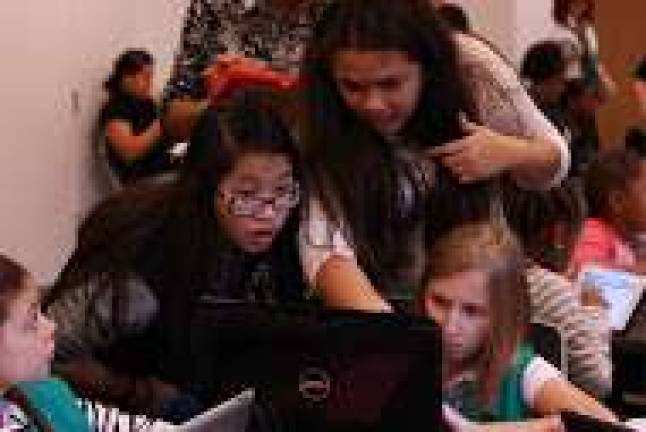 Girl Scouts Angelica Lee, 14, Maliyah Colon, 14, and Madeline Brown, 10, distil the nuances of programing languages at a TechJam event on Saturday. Photo: Maya Dangerfield