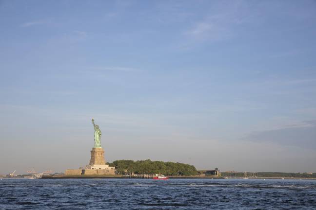 Spectators gathered on Liberty Island and atop the Statue of Liberty to watch the parade of aircraft and ships traveling along the Hudson River.