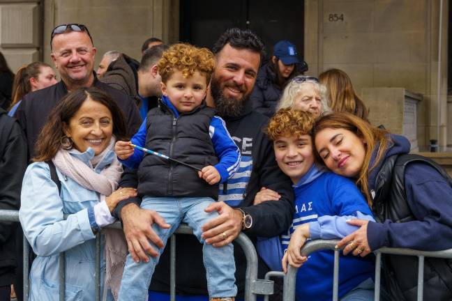 A Greek family enoying the parade outside 854 Fifth Avenue.