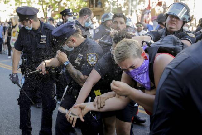 New York police officers use pepper spray on protesters during a demonstration Saturday, May 30, 2020 in Brooklyn. Protests were held throughout the city over the death of George Floyd, a black man who was killed in police custody in Minneapolis on Memorial Day.