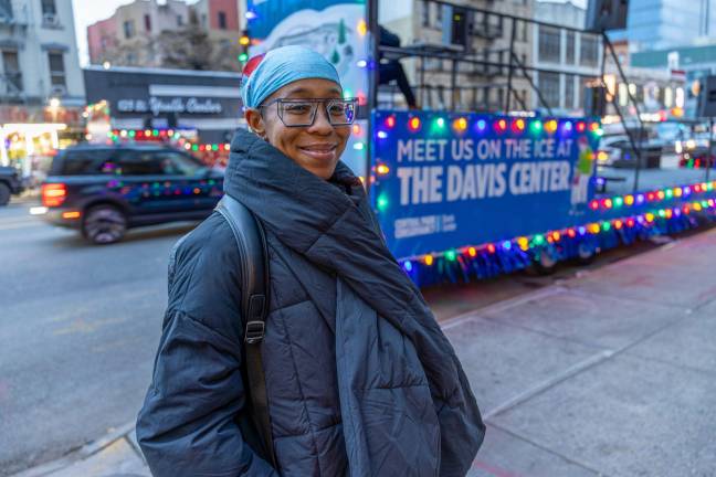 Stormy McNair smiling at the camera with an empty Central Park Conservancy branded parade float in the background.She grew up in Harlem and calls the northern end of the park her home neighborhood.