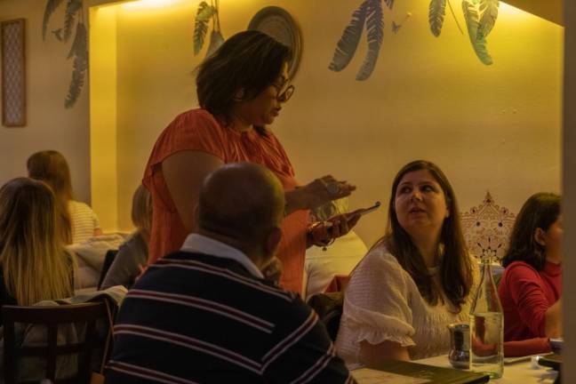 <b>As someone who grew up in large family and then married into one, Nupur says, she's always been a social person and loves interacting with diners. Here she is seen taking a family's dinner order at Mughlai</b>. Photo: Priyanka Rajput