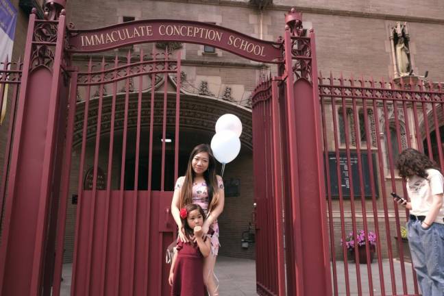 Leslie Wong picks up her daughter Lila who graduated from pre-k on June 16th, on the last day of classes at Immaculate Conception School, which is closing down. Photo: Beau Matic