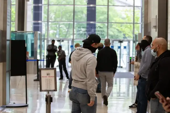 Federal agents wait in the lobby of 26 Federal Plaza to detain people after immigration hearings, May 28, 2025.