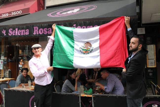 Sammy Musovic (left), the owner of Selena Rosa on Second Avenue, raises a Mexican flag to commemorate that country's independence day as well as a settlement of a dispute about the restaurant's name. Photo: Alexandra Zuccaro