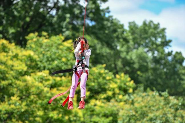 A girl sails past the trees on one of the festival’s most popular activities of the day: the zipline. Photo: NYC Parks / Daniel Avila