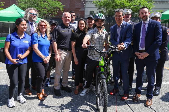 Commissioner Rodriguez, Commissioner Tucker, and others with a delivery worker receiving a fire-safe certified e-bike at the E-Bike Trade-In pilot program event.