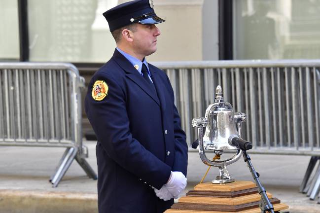 A firefighter from Ladder Co. 20, which was one of the first houses on the scene in 1911, tolls a bell 146 times as the names of the 123 young women and 46 men who died in the Triangle Shirtwaist Factory Fire are read aloud on March 25, marking 114 years since the deadly fire.