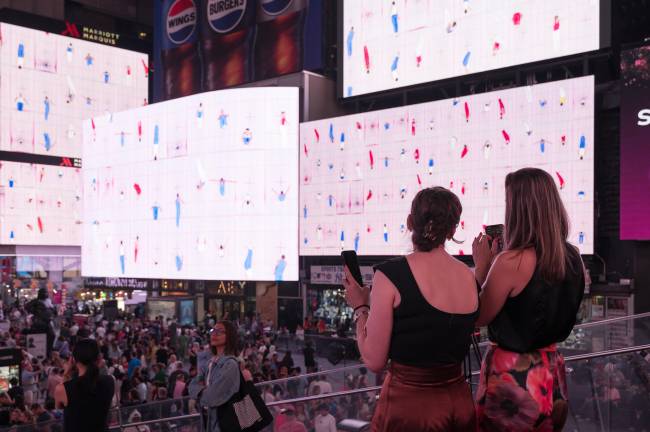 Young people enjoy Yuge Zhou’s installation, “Trampoline Color Exercise” in Times Square.