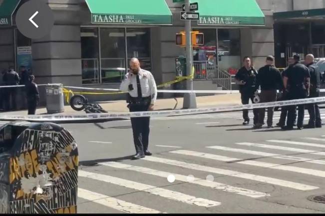 Police at scene of a fatal accident where a venerated synthwave artist George Smaragdis was knocked from e-bike after he was doored and fell under wheels of a tequila delivery truck. The e-bike he was riding west on Broome St. can be seen to the rear of the police officer.