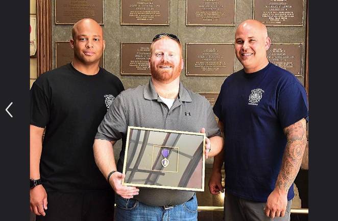 Firefighters Jonathan Bush (left) and Aaron Clark with Purple Heart recipient Charles O’Brien, June 2016.