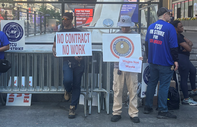 ”No Contract, No Work,” reads one sign held by one of the 3,000 striking workers outside Penn Station who walked off the job on May 16 at the stroke of midnight.