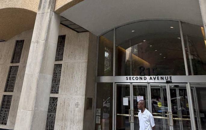 A worker stands outside the Episcopal HQ at 815 Second Ave. between East 42nd St. and East. 43rd Street on July 17. The building was still facing a full vacate order after beams buckeled inside nearby 235 E. 42nd St. in the former HQ of Pfizer.
