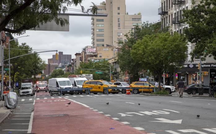Traffic is being stopped and redirected westbound on East 13th Street towards Second Avenue. Outside the intersection closure, there was honking and congested movement of vehicles.