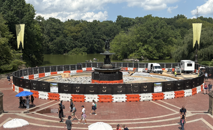 Bethesda Fountain from atop Bethesda Terrace, featuring the beginnings of construction and a handful of construction workers.
