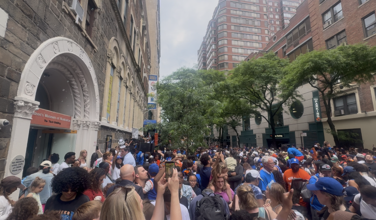 Children, parents, and caregivers gather outside the entrance of the Children’s Museum of Manhattan to celebrate the Knicks win with music, crafts, and other activities.