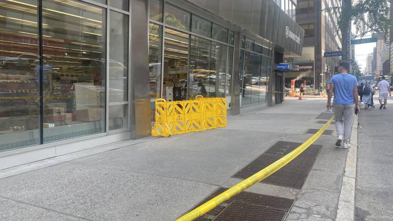 Yellow crime scene tape roped off the area in front of the drugstore at 711 Third Ave., but the store remained operational.