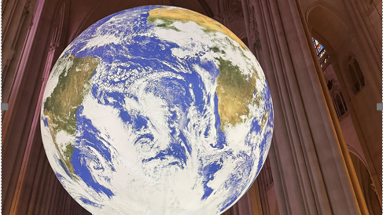 Luke Jerram’s monumental “Gaia” installation hangs aloft in the nave at the Cathedral of St. John the Divine. In Greek mythology, Gaia is the personification of our planet, often referred to as “Mother Earth.”
