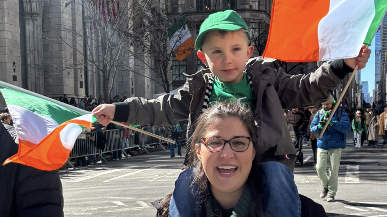 Amanda Brown from New Windsor, NY, gives a lift up Fifth Ave. to her son Cameron, who waves two tri-color flags.