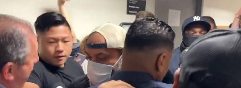 Lander (left) is attempting to stay connected to a migrant (center) who just had his case dismissed in criminal court but who was being taken into custody by ICE agents in a hallway at 26 Federal Plaza.