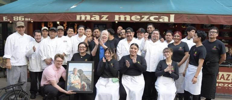 Mary Silva (center in blue shirt, clapping her hands), surrounded by her dedicated restaurant staff, is looking forward to Maz Mezcal’s next location and serving the neighborhood for decades to come.