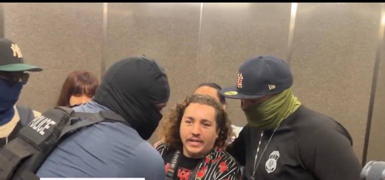 Veteran photojournalist Dean Moses (center) just as he is being grabbed by masked ICE agents and forced from a public elevator at 26 Federal Plaza, where he was covering immigration hearings.