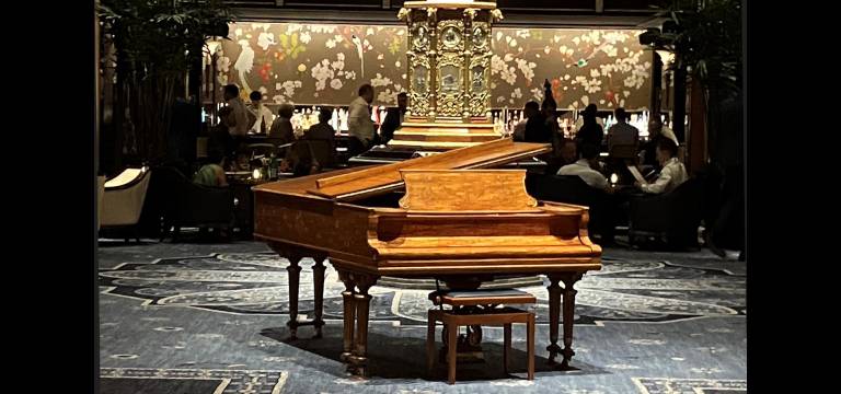 Cole Porter lived at the Waldorf Astoria from 1939 to 1964. His Steinway piano is on display in Peacock Alley, shown here with the bar in the background.
