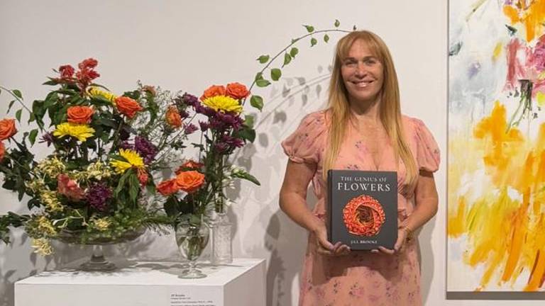 Flower historian and veteran journalist Jill Brooke photographed with her third and newest book, “The Genius of Flowers,” alongside some of Brooke’s blooms.