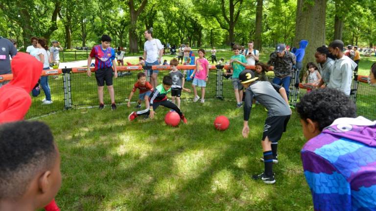 A group of kids play a ball game in the grass. Photo: NYC Parks / Daniel Avila