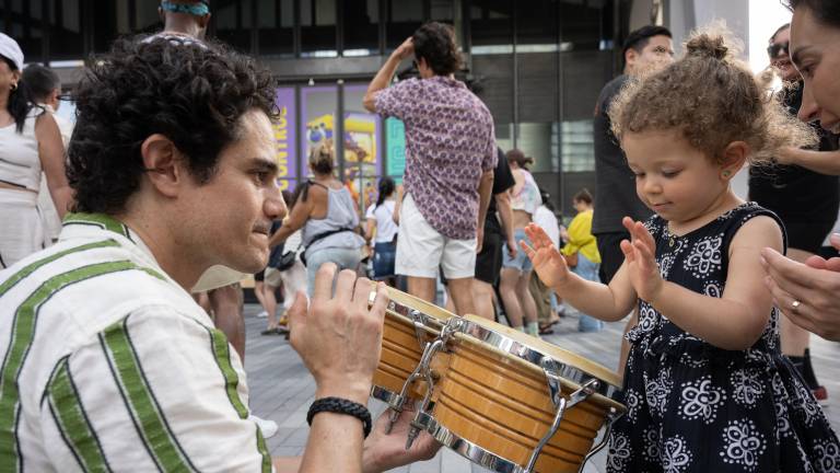 A child interacts with a musician during West Side Fest programming near the Whitney Museum.