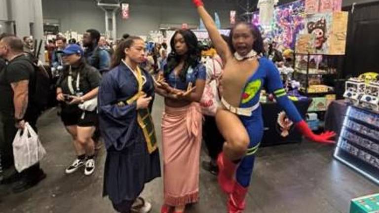 Three friends show off their cosplay: two Jujutsu Kaisen cosplaysSuguru Geto and Fumihiko Takaba surround Nico Robin from “One Piece.”
