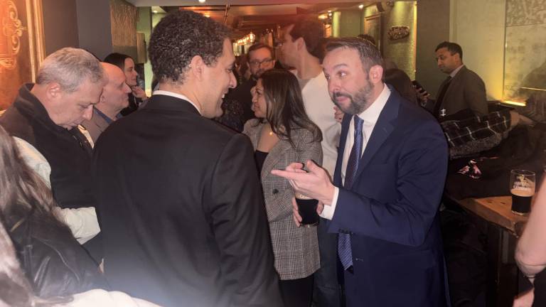 Keith Powers, who won the special election for New York State Assembly 74th District, gestures to his former City Council colleague Chris Marte at a victory party in Shades of Green Pub near Union Square.